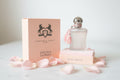 Parfums de Marly Delina La Rosée perfume bottle and packaging on a textured surface